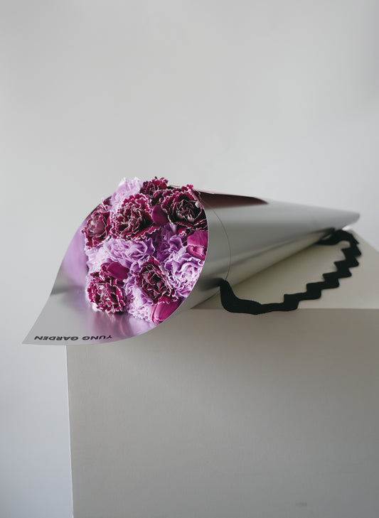 高級優雅的紫色康乃馨鬱金香母親節花束，包裹在銀色印有"YUNG GARDEN"牌子名稱的包裝纸中。
